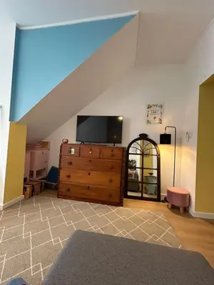 a living room with a tv on top of a dresser at Dolce Faro Niente Guest House in Faro