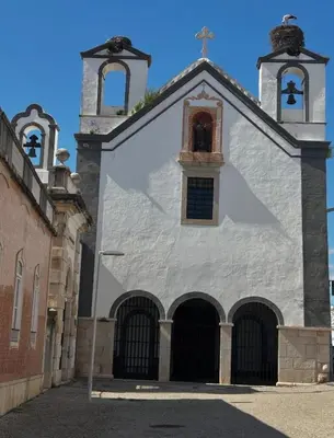 a white church with a cross on top of it at Dolce Faro Niente Guest House in Faro