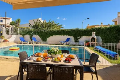 a table with fruit on it next to a pool at Villa Mar by Sunny Deluxe in Albufeira