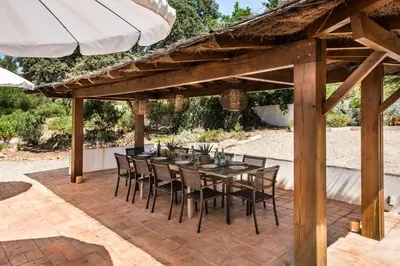 a patio with a table and chairs under an umbrella at Lovely Vacation Villa In Loulé in Loulé