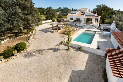 an outdoor dining room with a long table and chairs at Lovely Vacation Villa In Loulé in Loulé