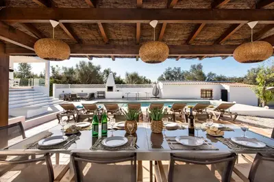 an outdoor dining area with a table and chairs and a pool at Lovely Vacation Villa In Loulé in Loulé