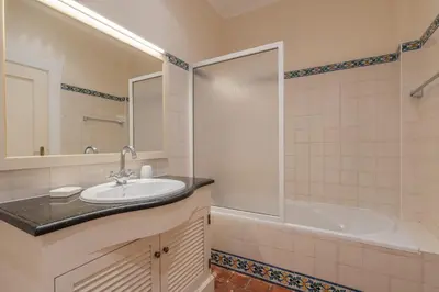 a bathroom with a sink and a tub and a shower at Villa Celia in Albufeira