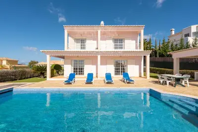 a villa with a swimming pool in front of a house at Villa Celia in Albufeira
