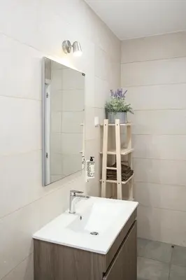 a kitchen counter with a sink and white cabinets at Casa Tomás in Faro