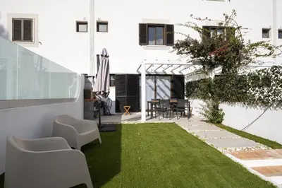 a small garden with grass and white chairs at Marina Búzios I & II - Vilamoura Marina by HD in Vilamoura