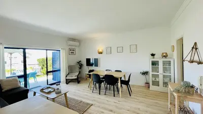 a living room and dining room with a table and chairs at Jardim da Oura by Check-in, Portugal in Albufeira