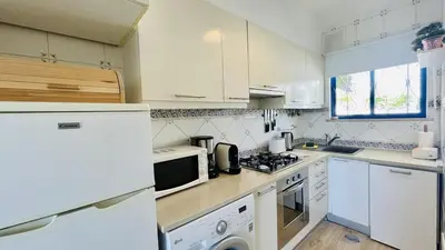 a kitchen with white appliances and a white refrigerator at Jardim da Oura by Check-in, Portugal in Albufeira