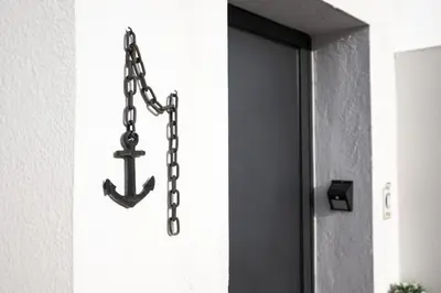 a metal anchor on a wall next to a door at Ancora Mar - Vilamoura Marina by HD in Vilamoura