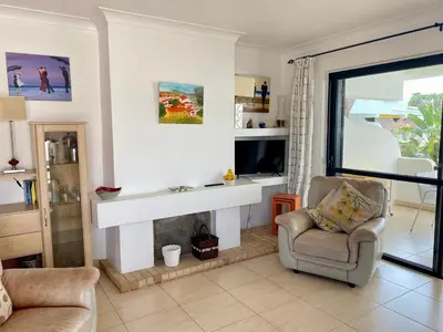 a living room with a fireplace and a chair at Solar Vilamoura Relaxing Apartment Stay in Quarteira