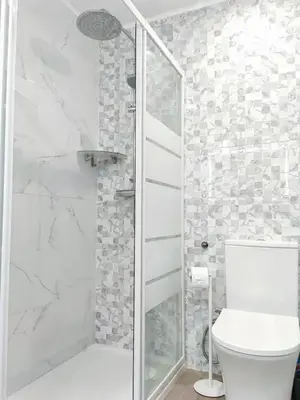 a white bedroom with a bed and a mirror at Sunny Condo facing the pool by Algarve Dream Holidays in Quarteira