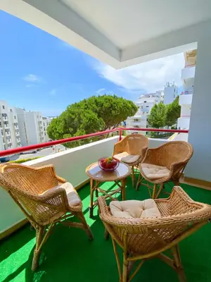 a balcony with chairs and a table on a ship at Sunny Condo facing the pool by Algarve Dream Holidays in Quarteira