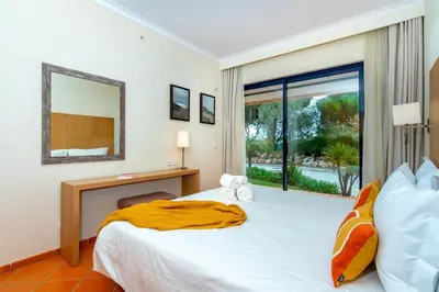 a hotel room with a bed and a large window at F5 Vila Sol AP Pool & Golf in Vilamoura in Quarteira