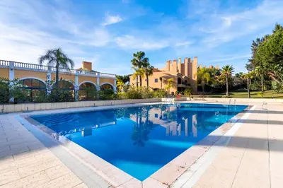 a swimming pool in front of a building at F5 Vila Sol AP Pool & Golf in Vilamoura in Quarteira