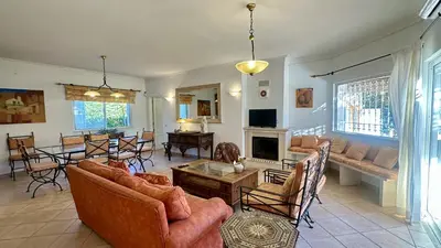a living room with a couch and a table and chairs at Pinheiro Manso by Check-in Portugal in Albufeira