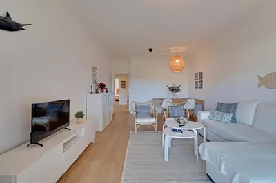 a living room with a couch and a tv at Las Palmeiras Vilamoura in Quarteira