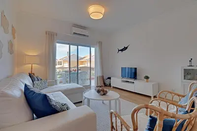 a living room with a couch and a table at Las Palmeiras Vilamoura in Quarteira