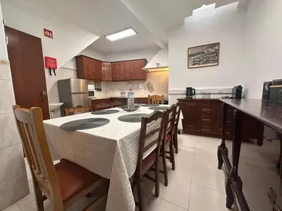 a kitchen with a table and chairs and a kitchen with a counter at Al-Gharb House - Vista Mar in Albufeira