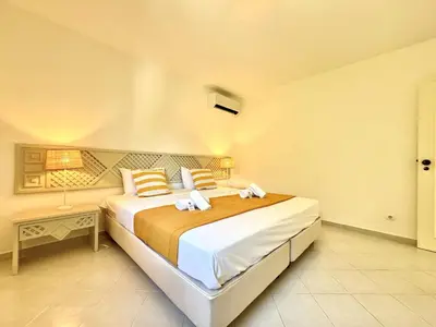 a bedroom with a large bed and a table at Albufeira Balaia Golf Vilage 8 With Pool by Homing in Albufeira