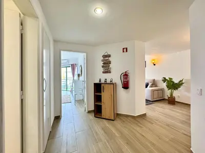 a living room with white walls and a wooden floor at Vilamoura Central Beach 1 With Pool by Homing in Vilamoura