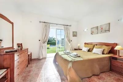 a bedroom with a large bed and a large window at Villa Portela in Loulé