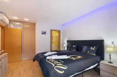 a bedroom with a large bed with a black comforter at Flat With Pool, Old Town Albufeira in Albufeira