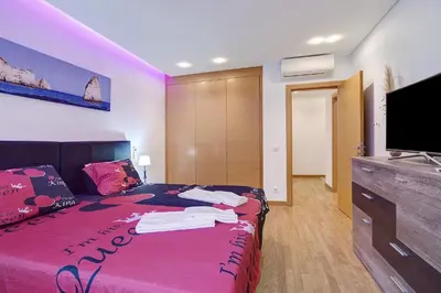 a bedroom with a bed and a flat screen tv at Flat With Pool, Old Town Albufeira in Albufeira