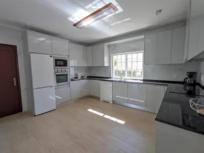 a kitchen with white appliances and a large window at Villa Quinta do Jolu by Villa Select in Guia