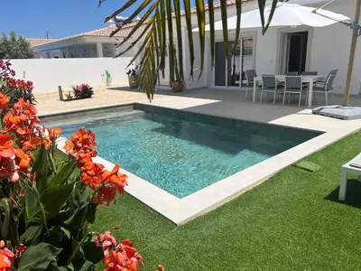 a swimming pool in the yard of a house at Casa Alegria in Tunes