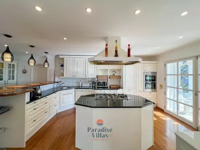 a kitchen with white cabinets and a large island at 7 Bedrooms, Main House, Bungalow, Private Pool in Fonte da Murta