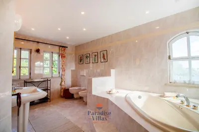 a bathroom with two sinks and a tub and two toilets at 7 Bedrooms, Main House, Bungalow, Private Pool in Fonte da Murta