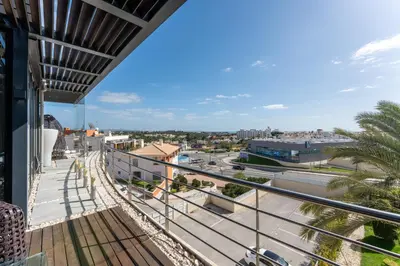 a balcony with a glass table and chairs on it at Penthouse Grand Noir in Guia