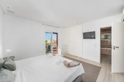 a white bedroom with a bed and a tv at Villa Gale by Vintage Travel in Galé