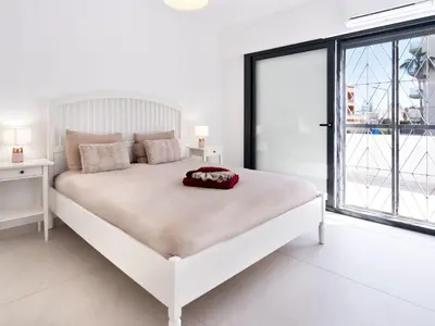 a white bedroom with a white bed and a large window at Holiday Home Aldeia Do Mar by Interhome in Vilamoura
