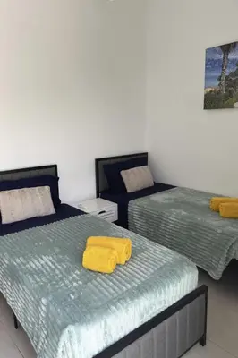 a bedroom with two beds with a yellow towel on them at Holiday Home Aldeia Do Mar by Interhome in Vilamoura