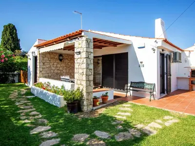 a white house with a bench in the yard at Holiday Home Lotus Villa 2- Albufeira by Interhome in Albufeira