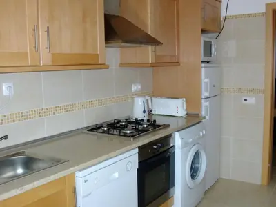 a kitchen with a stove top oven next to a washing machine at Apartment Wohnung mit Balkon by Interhome in Albufeira