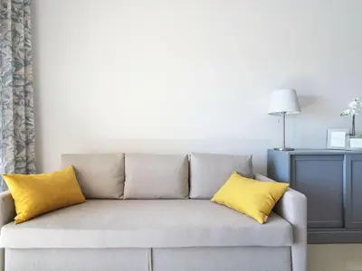 a couch with two yellow pillows in a living room at Apartment Elena 2 mit Blick auf das Wasser by Interhome in Albufeira