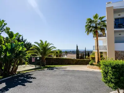 a driveway with palm trees in front of a building at Apartment Elena 2 mit Blick auf das Wasser by Interhome in Albufeira