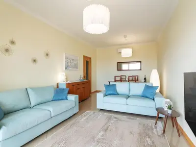 a living room with two blue couches and a table at Apartment Elena 1 mit Blick auf das Wasser by Interhome in Albufeira