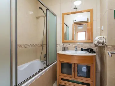 a bathroom with a tub and a sink and a shower at Apartment Elena 1 mit Blick auf das Wasser by Interhome in Albufeira