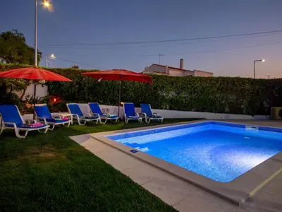 a swimming pool with chairs and umbrellas next to at Holiday Home Lotus Villa- Albufeira by Interhome in Albufeira
