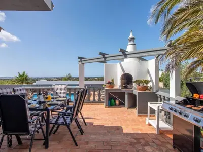 an outdoor kitchen with a table and chairs on a patio at Holiday Home Villa Monte Alegrete by Interhome in Loulé