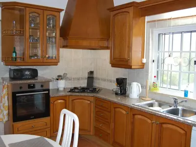 a kitchen with wooden cabinets and a sink at Holiday Home Villa Monte Alegrete by Interhome in Loulé
