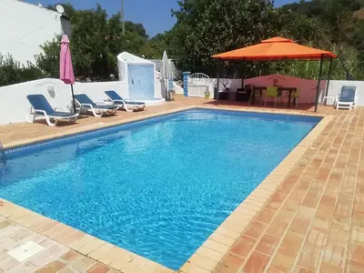 a swimming pool with chairs and an umbrella at Holiday Home Berghütte Villa Romao by Interhome in Barranco de Apra