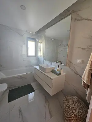 a white bathroom with a sink and a mirror at Apartamento Platinum in Faro