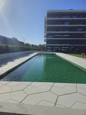 a pool of green water in front of a building at Apartamento Platinum in Faro