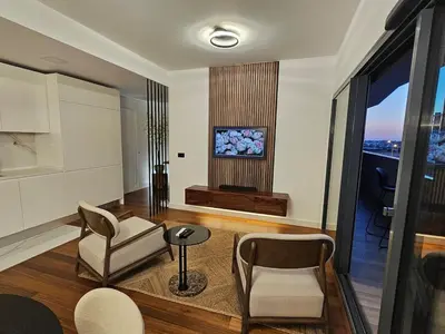a living room with two chairs and a tv at Apartamento Platinum in Faro