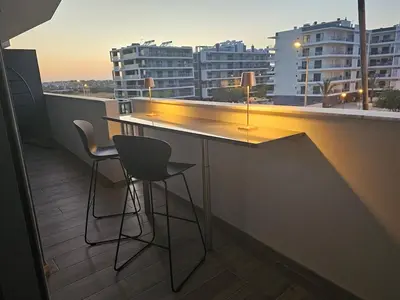a bar on the roof of a building with chairs at Apartamento Platinum in Faro