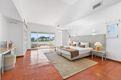 a bedroom with a large white bed and a window at Casa Mimosa in Vale do Lobo